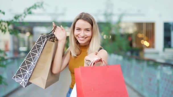 Portret Vrolijke Jonge Vrolijke Vrouw Tonen Winkelen Cadeau Papieren Tassen — Stockvideo