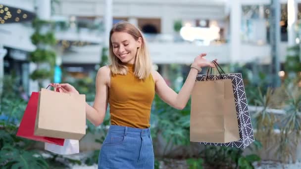 Vrolijke Jonge Shopaholic Vrouw Met Papieren Tassen Met Aankopen Glimlachend — Stockvideo