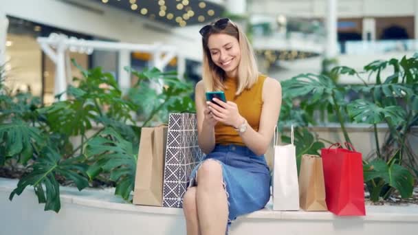 Jovem Consumidora Shopping Navega Bate Papo Usa Usando Smartphone Fêmea — Vídeo de Stock