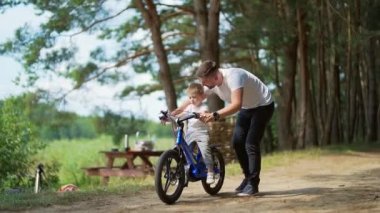 Peder Thelp oğluna bisiklet sürmeyi öğretiyor. Baba ve küçük çocuk parkta ya da orman yolunda bisiklet sürmeyi birlikte öğrenip destekliyor. Babalar Günü. Aile boş zamanlarını kampa gitmeyi öğrenerek geçirir.