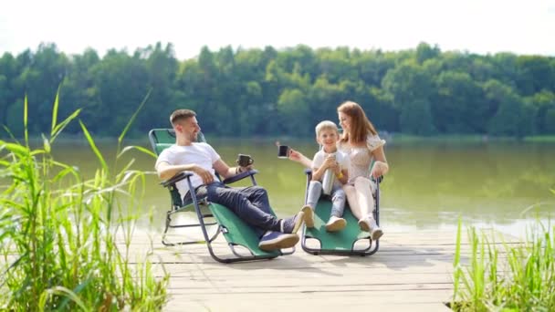 Vrolijk Jong Gezin Met Peuterkinderen Rustend Vouwstoelen Boven Het Meer — Stockvideo