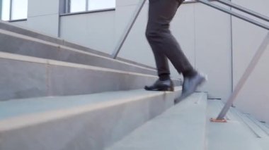 İş adamının merdivenlerden çıkışını kapatın. Erkek işadamı merdivenleri çıkıyor. İş adamı ofis binasının merdivenlerinden çıkıyor. Başarılı bir kariyeri olan kendinden emin bir adam.