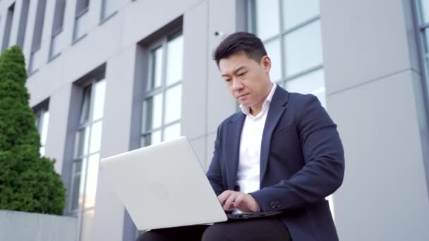Männliche Asiatische Geschäftsmann Arbeiten Mit Laptop Online Draußen Auf Bank — Stockvideo
