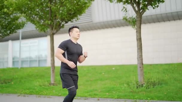 Junger Asiatischer Mann Läuft Die Straße Hinunter Auf Städtischem Hintergrund — Stockvideo