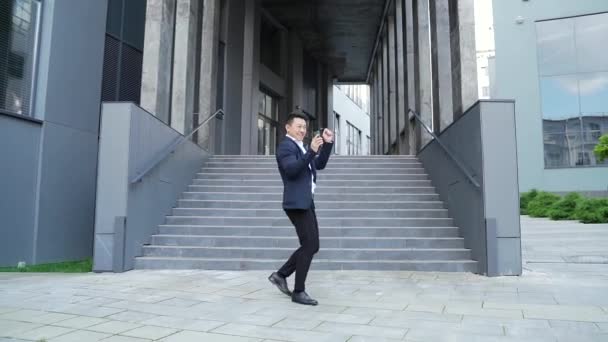 Munter Glad Asiatisk Forretningsmand Dansende Trappen Kulisse Moderne Kontorbygning Udenfor – Stock-video