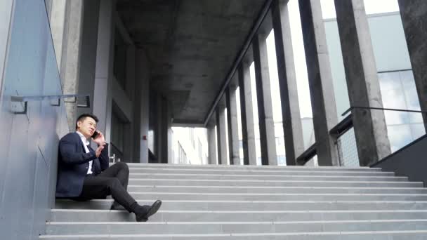 Молодой Азиатский Депрессивный Мужчина Сидит Лестнице Улице Рядом Офисным Зданием — стоковое видео