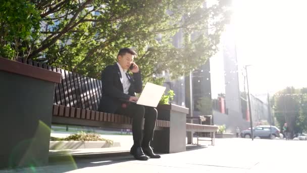 Молодой Азиатский Бизнесмен Фрилансер Сидящий Скамейке Запасных Работающий Ноутбуком Городском — стоковое видео