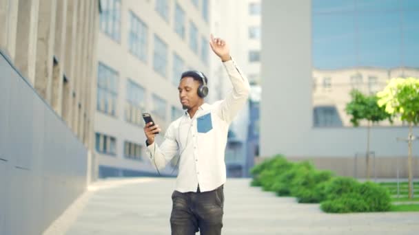 Mladý Veselý Aktivní Afroameričan Chodí Sluchátky Mobilní Telefon Těší Poslouchat — Stock video