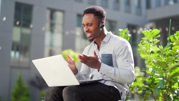 아프리카 미국인 프리랜서가 헤드셋 노트북으로 온라인상에서 싸우고 회의나 장거리 회의가 — 비디오