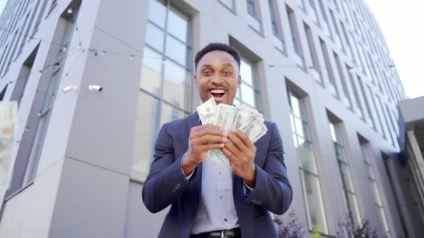 幸せな成功したアフリカ系アメリカ人ビジネスマンカウント スロー ショーオフ フロント 現代的なオフィスビルカメラを見て現金お金の背景を祝う賭け株式市場での勝者の成功 — ストック動画