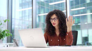 Hüsrana uğramış iş kadını, modern bir iş ofisindeki iş yerinde dizüstü bilgisayarını kullanarak işlem yapmakta zorlanıyor. Kafası karışmış kadın çalışanın bilgisayarla ilgili sorunları var