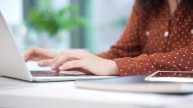 Modern ofiste dizüstü bilgisayarda klavye kullanan kadınların ellerini kapat. Bir iş kadını, masa başında oturan bir bilgisayarda çalışıyor. Teknoloji kullanımı ve profesyonel çalışma ortamı kavramı