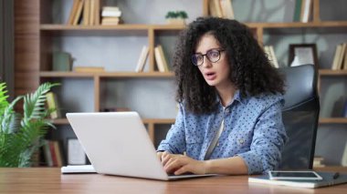 Laptopta kötü haber okuyan üzgün bir kadın ofiste oturuyor. Şok olmuş genç serbest çalışan kadın iş kadını, bilgisayardaki mesajla bunalıma girmiş ve olumsuz tebligat almış.