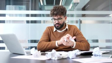 Hayal kırıklığına uğramış işadamının iş yerindeki evrak işleriyle ilgili sorunları var. Üzgün yatırımcı çalışmaktan yoruldu. İşçi umutsuzluğa kapılır, belgeleri ezer ve masaya atar.