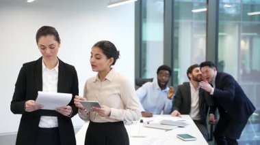 Bir grup erkek çalışan ofiste iki kadın iş arkadaşının arkasında fısıldaşıyor. Meslektaşlar kadınların arka planında dedikodu yapıp alay ediyorlar. İş yerinde zorbalık, mafya, kadın hakları ve cinsiyet ayrımcılığı sorunları