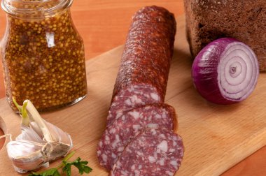 Ahşap bir masa üzerinde bıçakla dilimlenmiş sosis