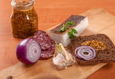 Domuz yağı soğan ve bıçak ile ahşap masa yatay dilimlenmiş