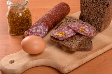 Ahşap bir masa üzerinde bıçakla dilimlenmiş sosis