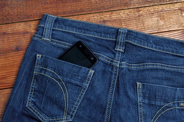 Smartphone ve starých kalhot na pozadí — Stock fotografie