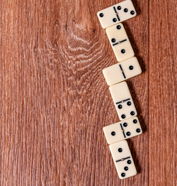 Dominostycken på den bruna trä bord bakgrund — Stockfoto