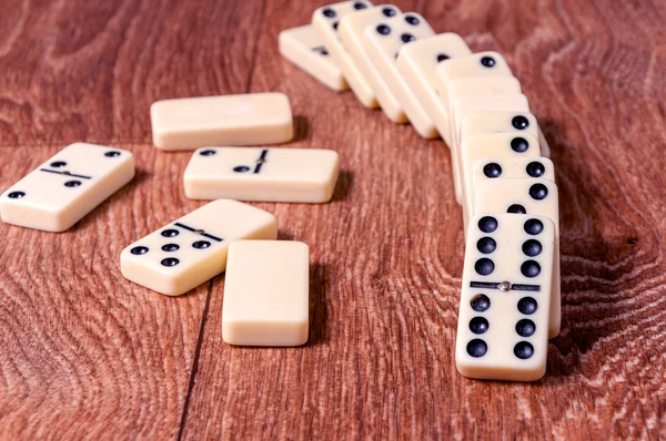 Peças de dominó sobre o fundo da mesa de madeira marrom — Fotografia de Stock