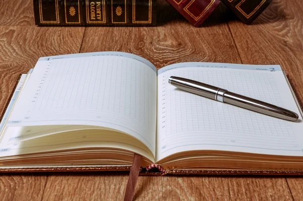 Bloc de notas y bolígrafo sobre mesa de madera — Foto de Stock