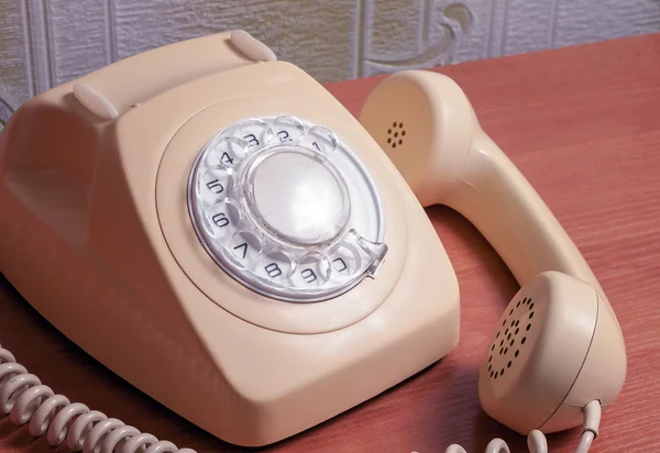 Retro telefon na dřevěný stůl v přední barevných přechodů — Stock fotografie