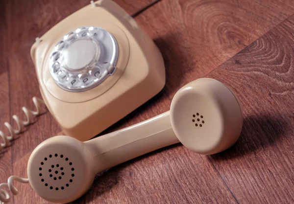 Retro telefon na dřevěný stůl v přední barevných přechodů — Stock fotografie