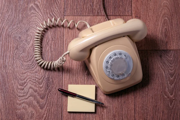Retro telefon na dřevěný stůl v přední barevných přechodů — Stock fotografie