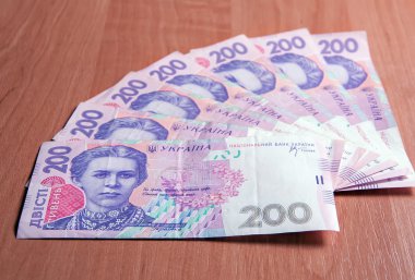 Ukrainian banknotes for two hundred hryvnias on a wooden table clipart