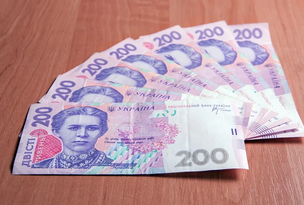 Ukrainian banknotes for two hundred hryvnias on a wooden table — Stock Photo, Image