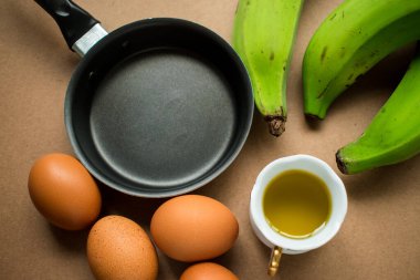 Yağlı siyah tava, biraz yumurta ve kızarmış yeşil muz. 