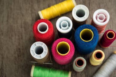 Terzi dükkanındaki bir masanın üzerinde çok farklı renkte iplikler var.