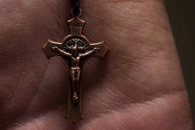 Beyaz el küçük kahverengi ahşap bir tespih tutuyor. 