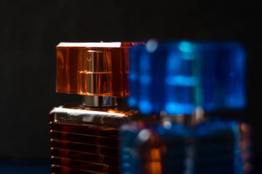 Cam turuncu şişe ve gri arka planı olan mavi şişe losyonu.  