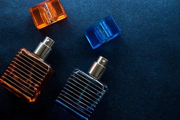 Mavi bir yüzey üzerinde cam turuncu şişe ve mavi şişe losyonu. 