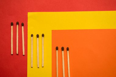 Bazı ahşap kibritler klorlu sarı, kırmızı ve turuncu yüzeyde