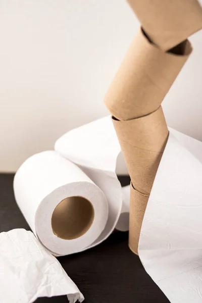 Some toilet paper carton and a white toilet paper on a wooden table with a white background