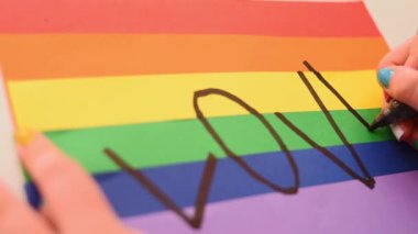 Renkli gökkuşağı arka planında siyah bir işaret ile el yazısı aşkı, lgbt sembolü 