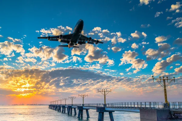Airplane  landing at sunset — Stock Photo, Image