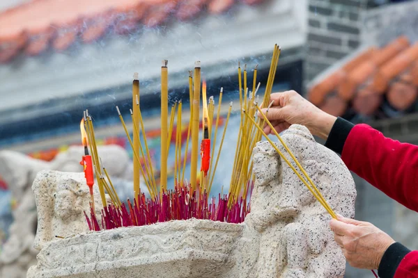 Mãos acenando varas de incenso de fumar no Templo — Fotografia de Stock