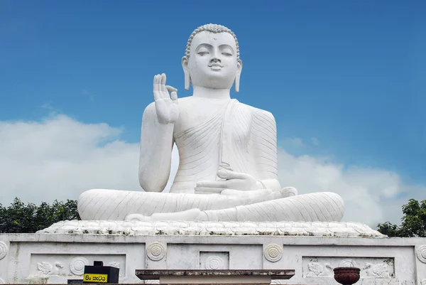 Bílá socha sedícího Buddhy (Siddharta Gautama) s zvedl pravou ruku v gestu "vitarka" Royalty Free Stock Fotografie