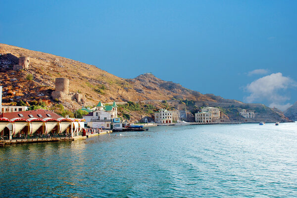Embankment of Balaclava town on the background of the ruins of the fortress Chembalo
