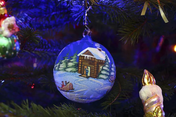 Christmas ball with a house and a sleigh on Christmas tree — Stock Photo, Image