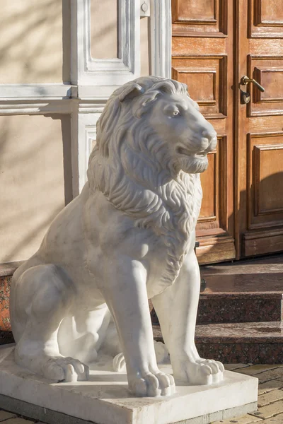 Lion of marble on the street in front of the building — Stock Photo, Image