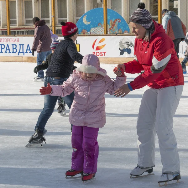 Mother teaches daughter to stand on skates — Stock Photo, Image