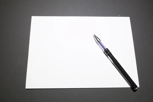 Sjabloon leeg vel papier en een pen — Stockfoto