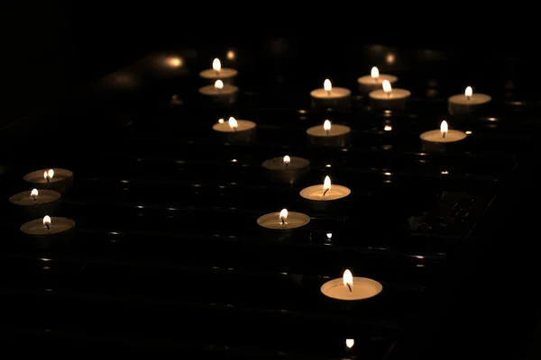 Achtergrond van vele aangestoken kaarsen in de kerk — Stockfoto