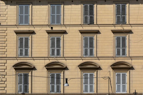Gelbe Außenwand des Altbaus mit Fenstern und Rollläden — Stockfoto