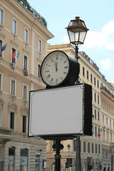 Blank banner with clock on street in Italy — Stock Photo, Image